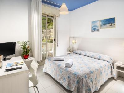 Bright room with double bed, balcony, TV, and marine-themed decor.