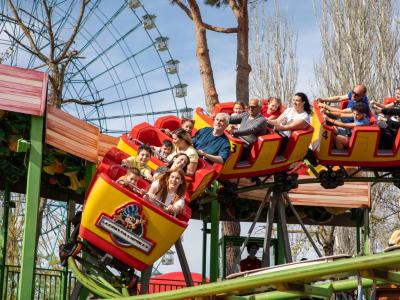 Des gens s'amusent sur des montagnes russes dans un parc d'attractions.