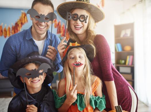 Famiglia felice con maschere di Halloween, si divertono insieme a casa.