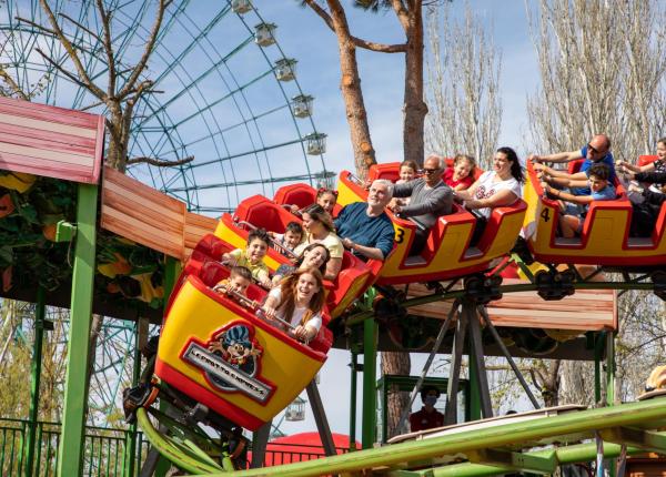 Des gens s'amusent sur des montagnes russes dans un parc d'attractions.