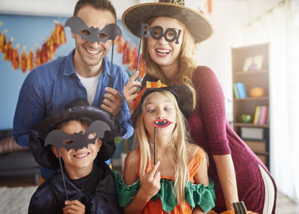 Glückliche Familie mit Halloween-Masken, haben Spaß zusammen zu Hause.